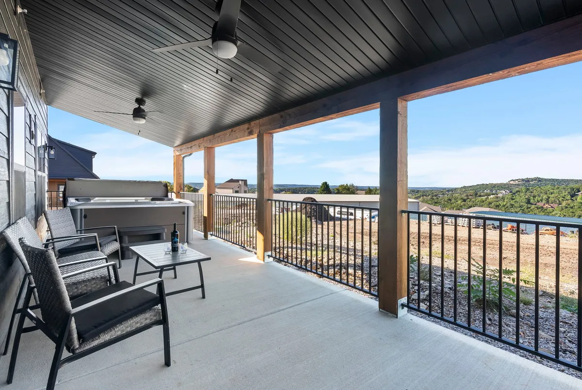 An inviting outdoor area featuring a private hot tub, comfortable seating, and panoramic views of the surrounding landscape. The tranquil mood is perfect for adults seeking relaxation and scenic moments.